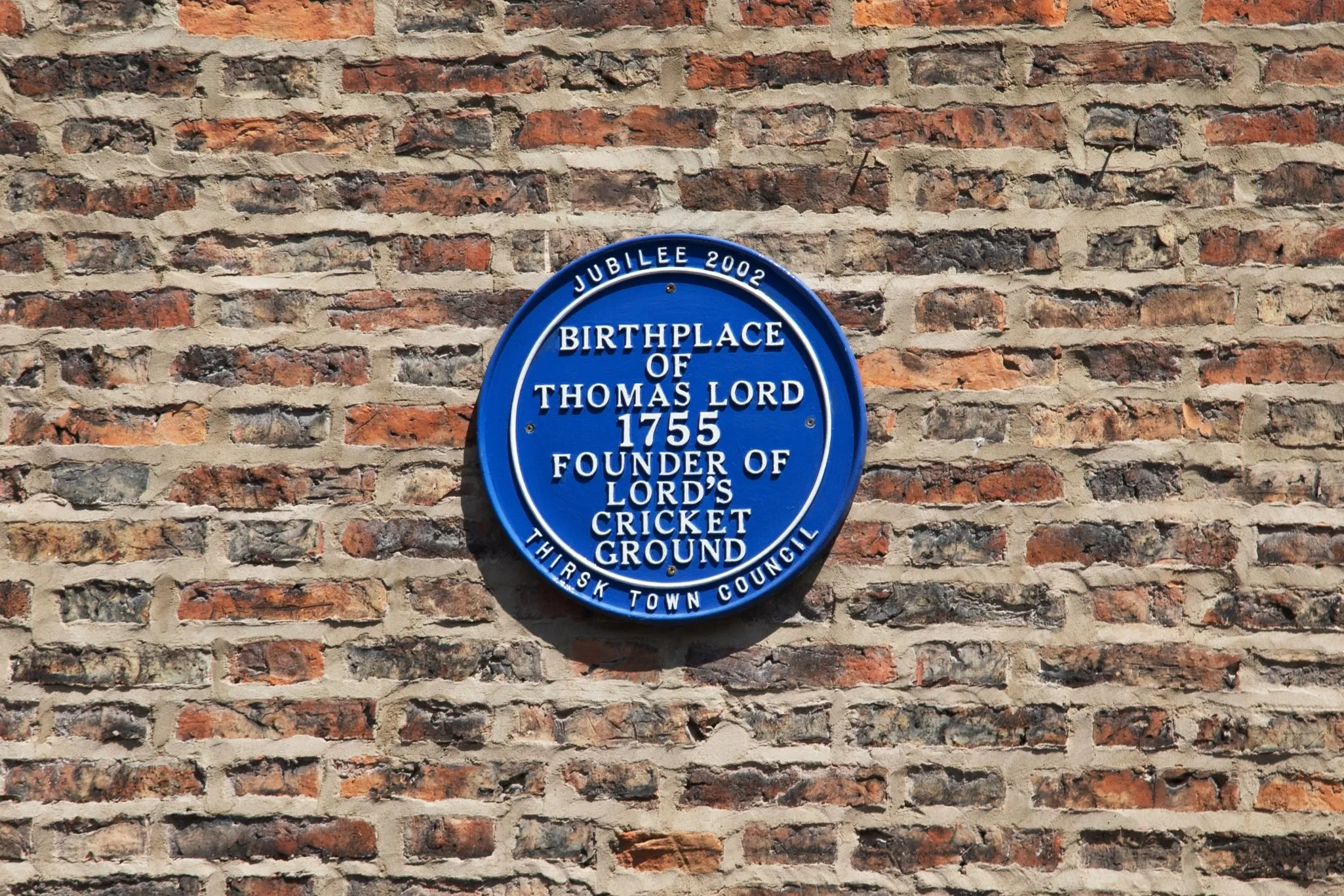 Blue plaque on home showing historical significance