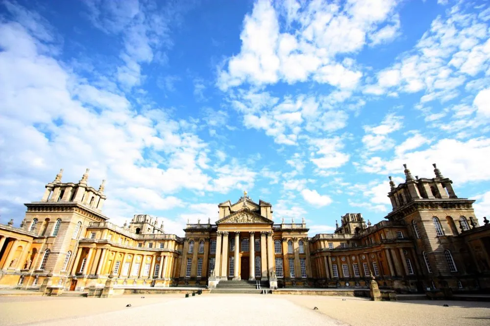 Facade of a grand historic building with tall columns and ornate architecture under a partly cloudy sky.